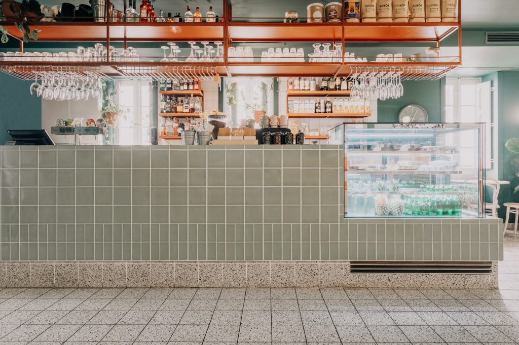 Elephant Shoe cafe restaurant interior design with a central bar and neutral tones