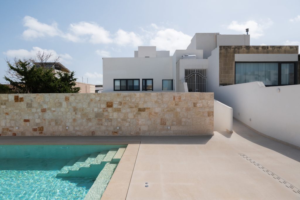 Outdoor pool area with stone wall