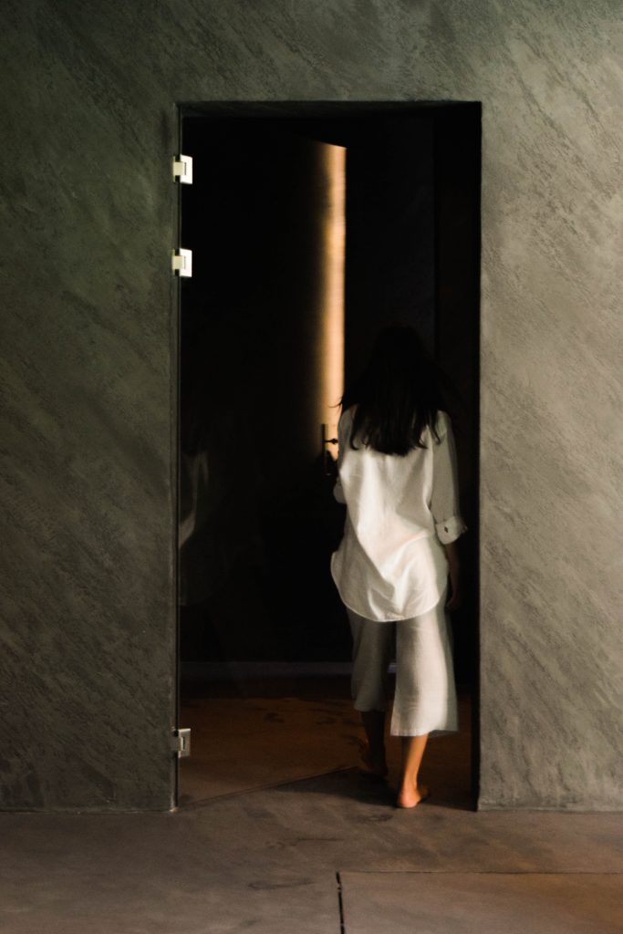 woman walking into modern bathroom interiors